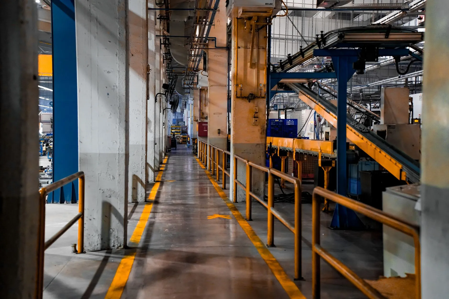 Vista ampla do interior de uma fábrica com linha de produção automatizada