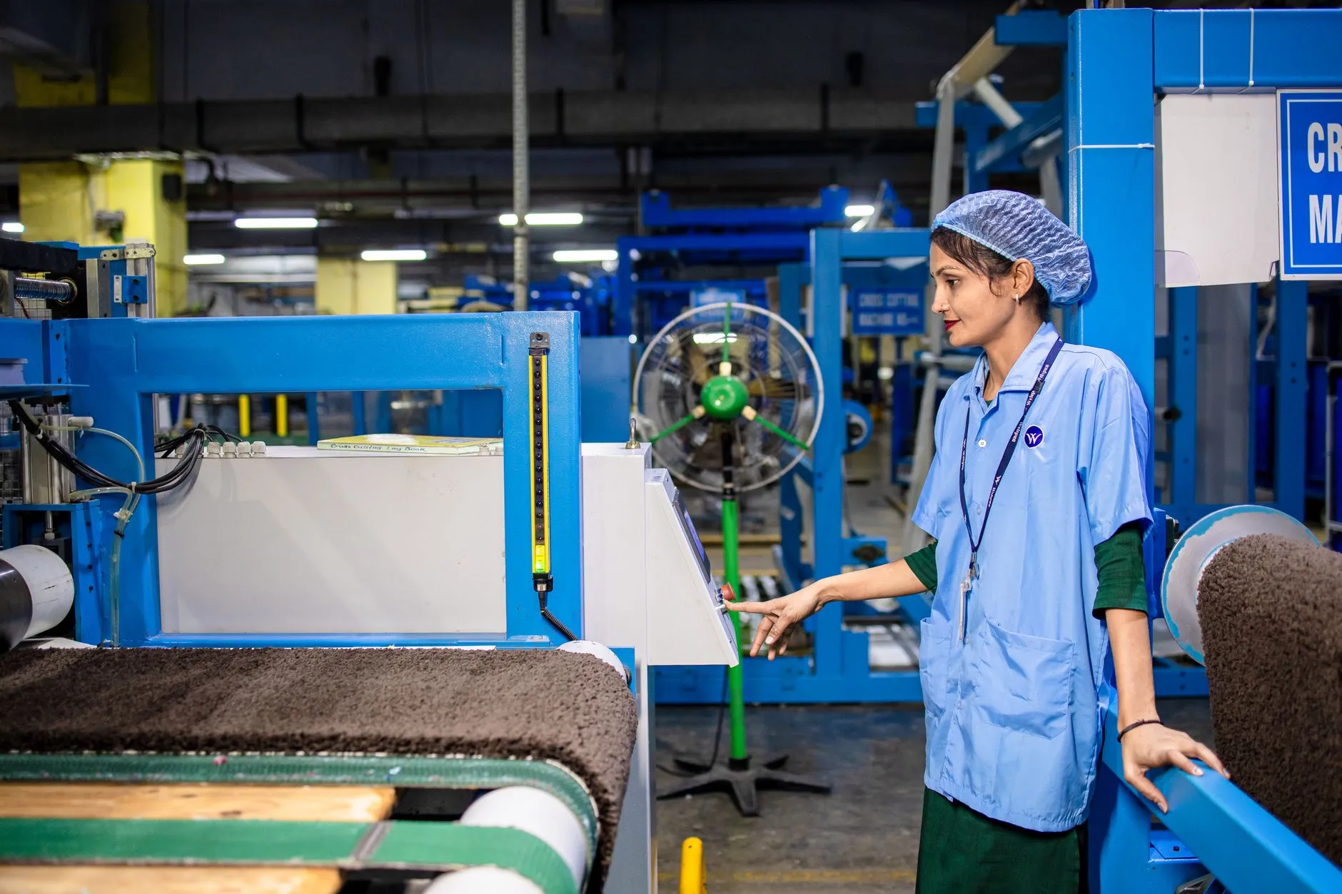 Operadora acompanhando máquina em linha de produção